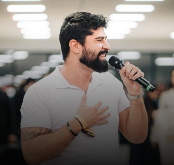 Cícero Alves sorrindo, com o microfone
